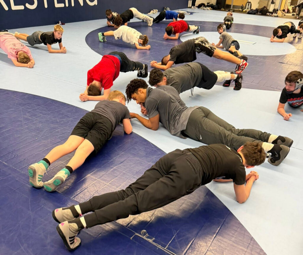 SCH Wrestling Club Students engaging in a high intensity Planking workout to prepare themselves for the days Wrestling Lesson