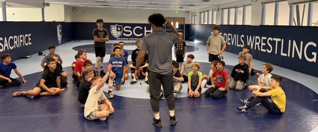 SCH Students Listening to a Coach discuss Wrestling moves in the SCH Wrestling Room in Philadelphia PA